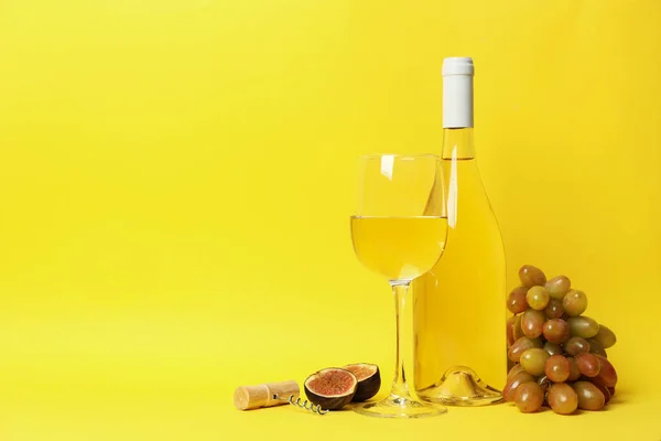 Composition with wine and fruits on yellow background