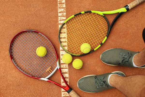 Man Fötter Racketar Och Tennisbollar Lera Domstol Ovanifrån — Stockfoto