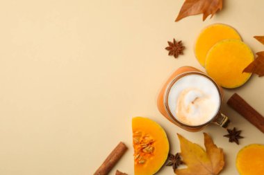 Bej arka planda balkabağı latte, balkabağı, yaprak ve tarçın karışımı