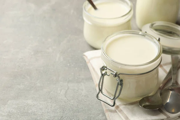 Glasburkar Yoghurt Skedar Och Servett Grå Bakgrund — Stockfoto