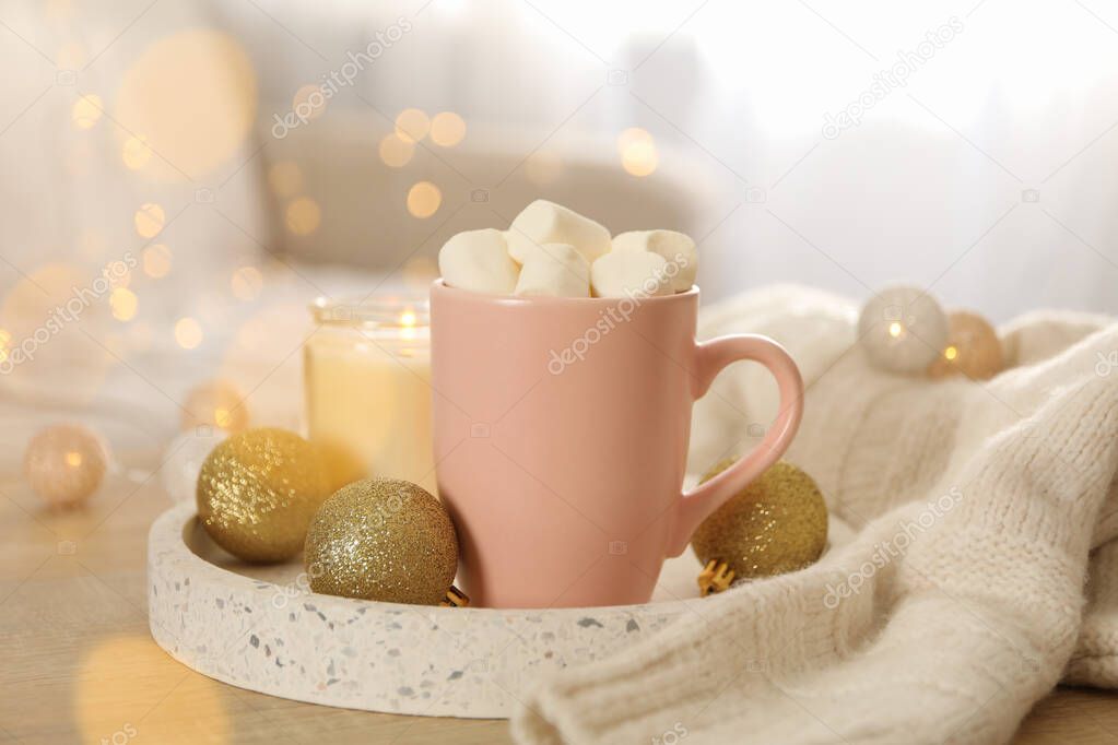Winter concept with cup of coffee with marshmallow and blurred lights