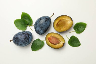 Beyaz arka planda taze erik ve yapraklar, üst görünüm