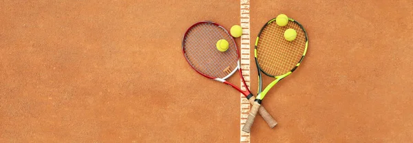 Tennis racquets with tennis balls on clay court