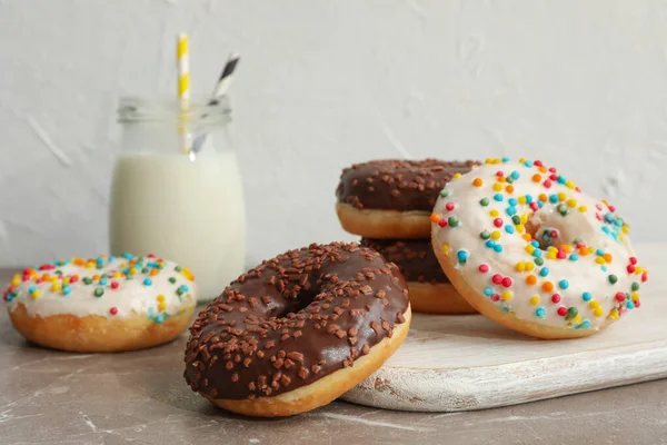 Milchglas Und Leckere Donuts Auf Grauem Tisch — Stockfoto