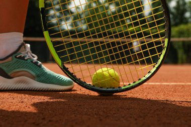 Killi sahada kadın bacağı, raket ve tenis topu