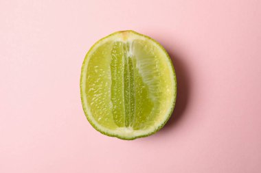 Pembe arka planda taze limonun yarısı