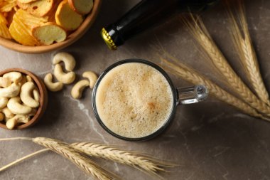 Gri arka planda bira, buğday ve atıştırmalıklar, üst manzara