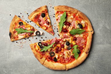 Gri arka planda lezzetli et pizzası, üst manzara.