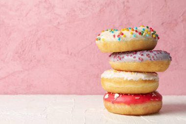 Beyaz masada pembe arka planda lezzetli çörekler.