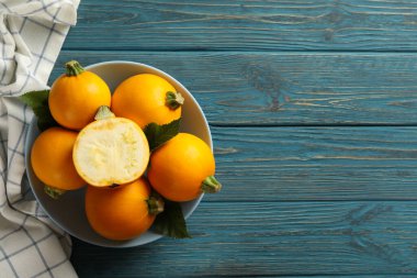 Yuvarlak kabaklı kase ve ahşap masada peçete.