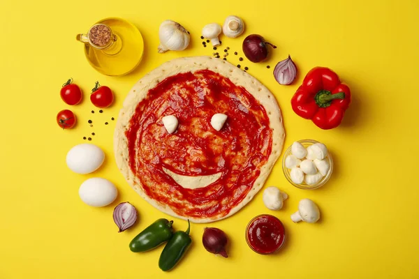 Sarı arka planda pizza pişirmek için gerekli malzemeler, üst görünüm