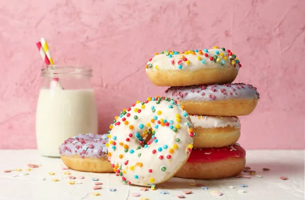 Milch Und Leckere Donuts Vor Rosa Hintergrund — Stockfoto