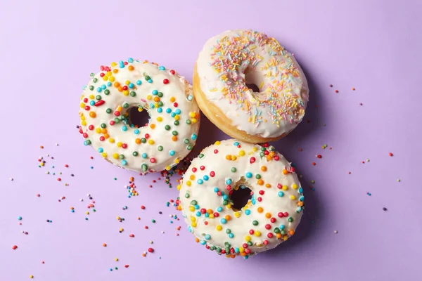 Drei Leckere Donuts Auf Violettem Hintergrund Draufsicht — Stockfoto