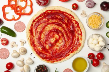 Beyaz arkaplanda pizza pişirmek için gerekli malzemeler, üst görünüm