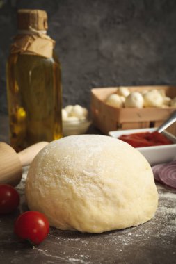 Gri arkaplanda pizza pişirmek için gerekli malzemeler