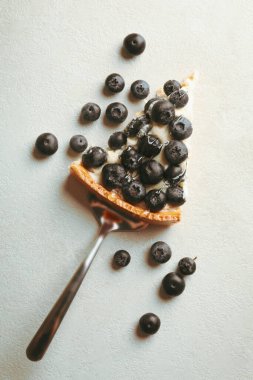 Gri arkaplanlı yaban mersinli tart dilimi