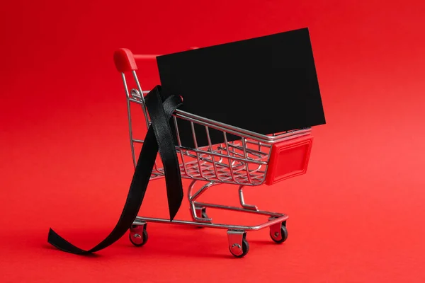 Shop trolley with tag on red background