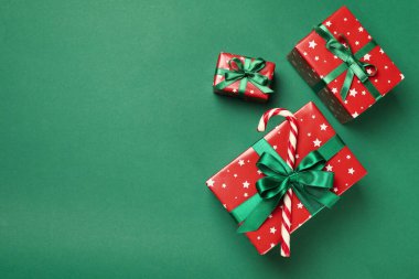 Yeşil arka planda Noel kutuları ve baston şekerler