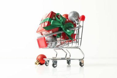 Noel kutulu alışveriş arabası ve beyaz arka planda aksesuarlar.