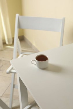 Beyaz ahşap masada bir fincan çay