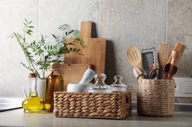 Mutfak masasında farklı malzemeler, vazoda bitki var.