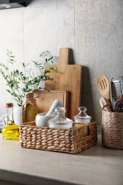 Mutfak masasında farklı malzemeler, vazoda bitki var.