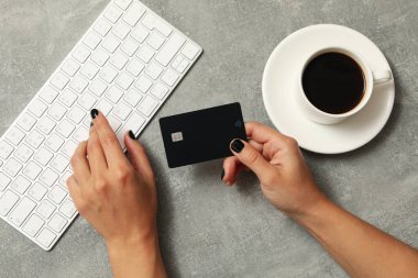 Gri arka planda, klavye ve kahve ile kadın el ele tutuşma kartı.