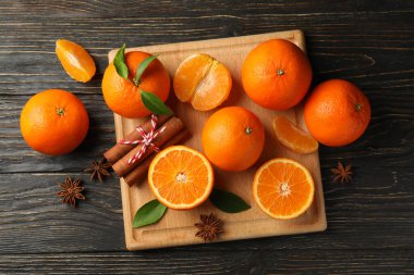 Ahşap arka planda mandalinalı ve tarçınlı tahta