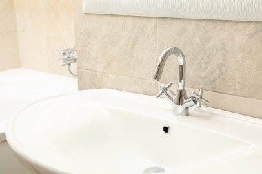 Modern, rahat banyoda açık bej renkte lavabo.