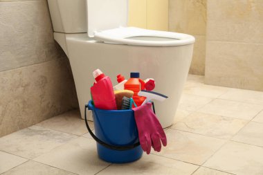 Modern banyoda temizlik ürünleriyle dolu bir kova.