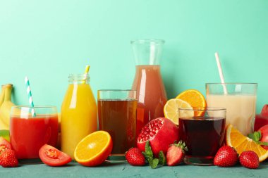 Yeşil arka planda farklı meyve suları bulunan bardak ve şişe kavramı