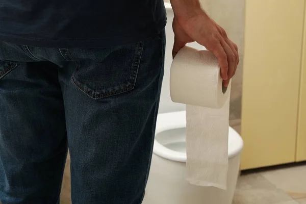 Мужчина Стоит Возле Туалета Держит Туалетную Бумагу — стоковое фото