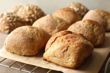 Gri arka planda taze pişmiş çöreklerle soğutma rafı.