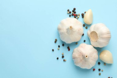 Mavi arka planda çiğ sarımsak ve biber.