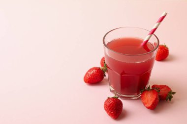 Pembe arka planda taze çilek suyu.