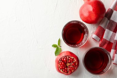 Beyaz masada taze nar suyu bardakları, üst manzara.