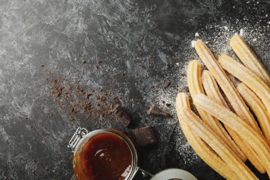 Koyu masada churros ve çikolatalı öğle yemeği kavramı.