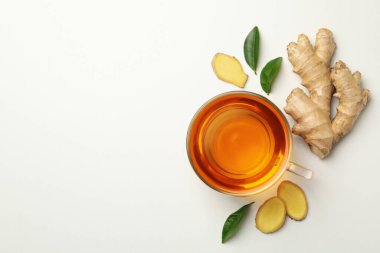 Taze zencefil ve beyaz arka planda bir fincan çay.