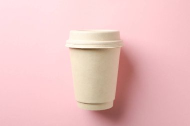 Pembe zemin üzerinde boş kağıt bardak, metin için boşluk