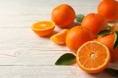 Beyaz ahşap zemin üzerinde olgun tatlı mandalinalar, metin için boşluk