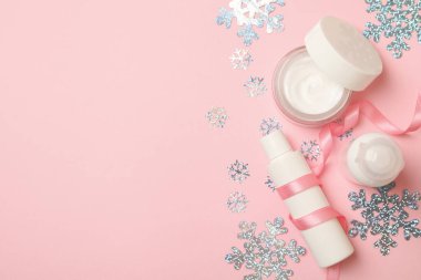 Pembe arka planda kozmetik ürünleri ve kar taneleri, metin için boşluk