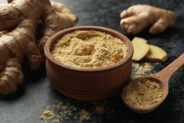 Siyah dumanlı arka planda zencefil tozu ve kase