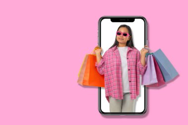 Genç kadın, Kara Cuma 'yı kutlayan canlı alışveriş çantaları taşıyor.