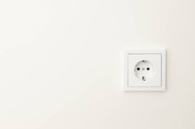 Standart elektrik prizi pürüzsüz beyaz bir duvara monte edildi