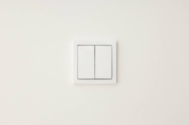 Düz beyaz duvar tasarımına karşı basit beyaz ışık düğmesi