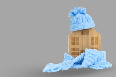 Mavi şapkalı ahşap bir ev ve rahat bir eşarba sarılmış.