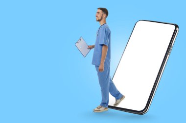 Mavi önlüklü, elinde dosya ve akıllı telefon olan doktor.