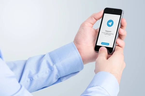 Telegram messenger na wyświetlaczu iphone w rękach mężczyzna — Zdjęcie stockowe