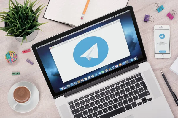 Телеграма messenger логотип на ноутбук і смартфон екрани — стокове фото