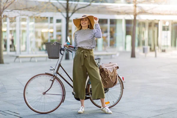 有魅力的年轻女子站在她的自行车在城市 — 图库照片